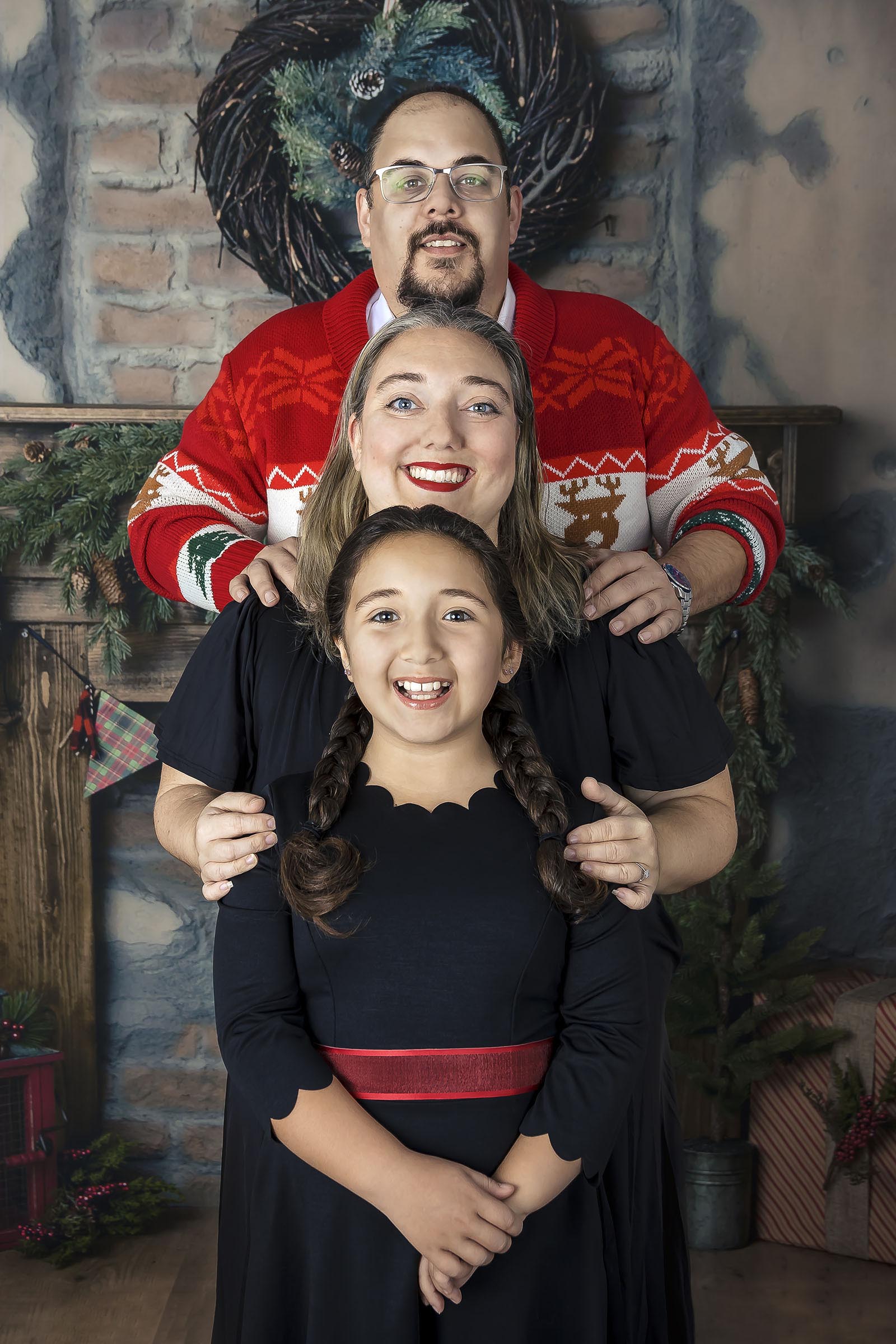 Beaux-arts portrait famille avec jeune fille qui se colle et sourit en studio fond rustique par Tobi Malette photographe Vaudreuil-Soulanges et ouest de l'ile de montreal
