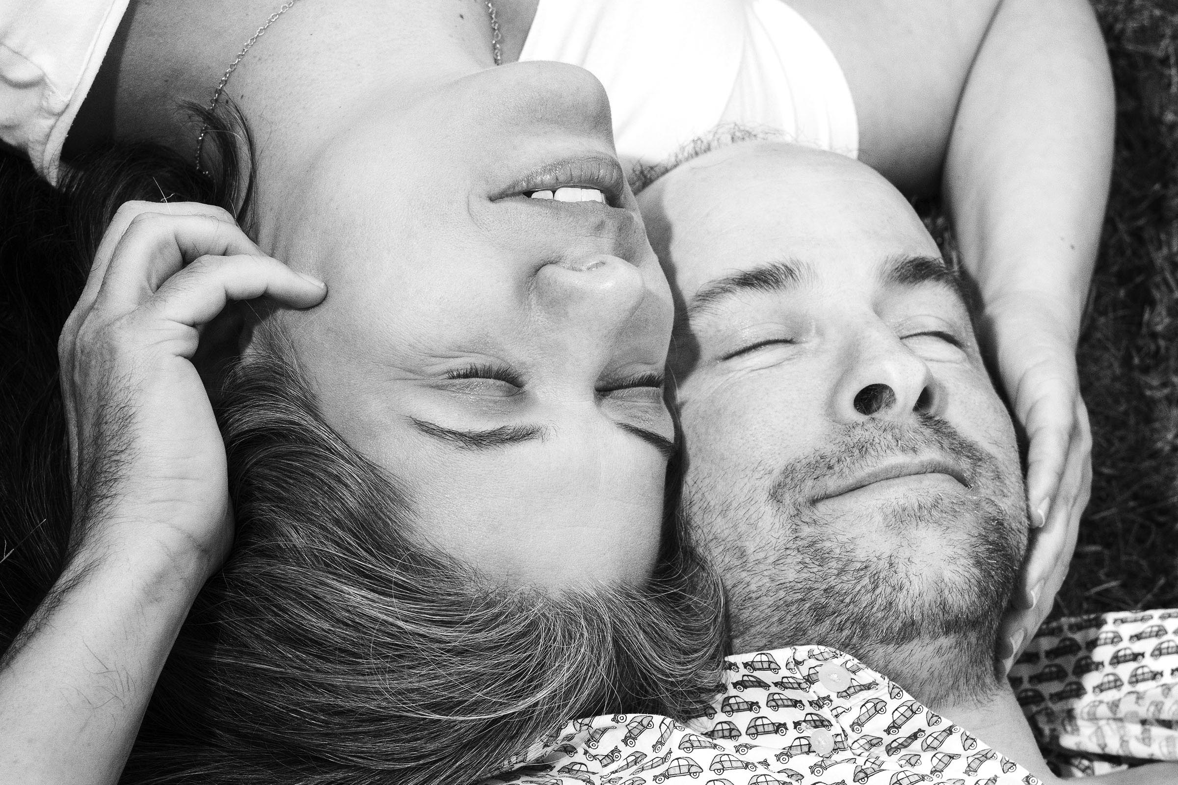 Portrait noir et blanc couple femme homme couché au sol se tenant les visages par Tobi Malette photographe Vaudreuil-Soulanges et ouest de l'ile de montreal