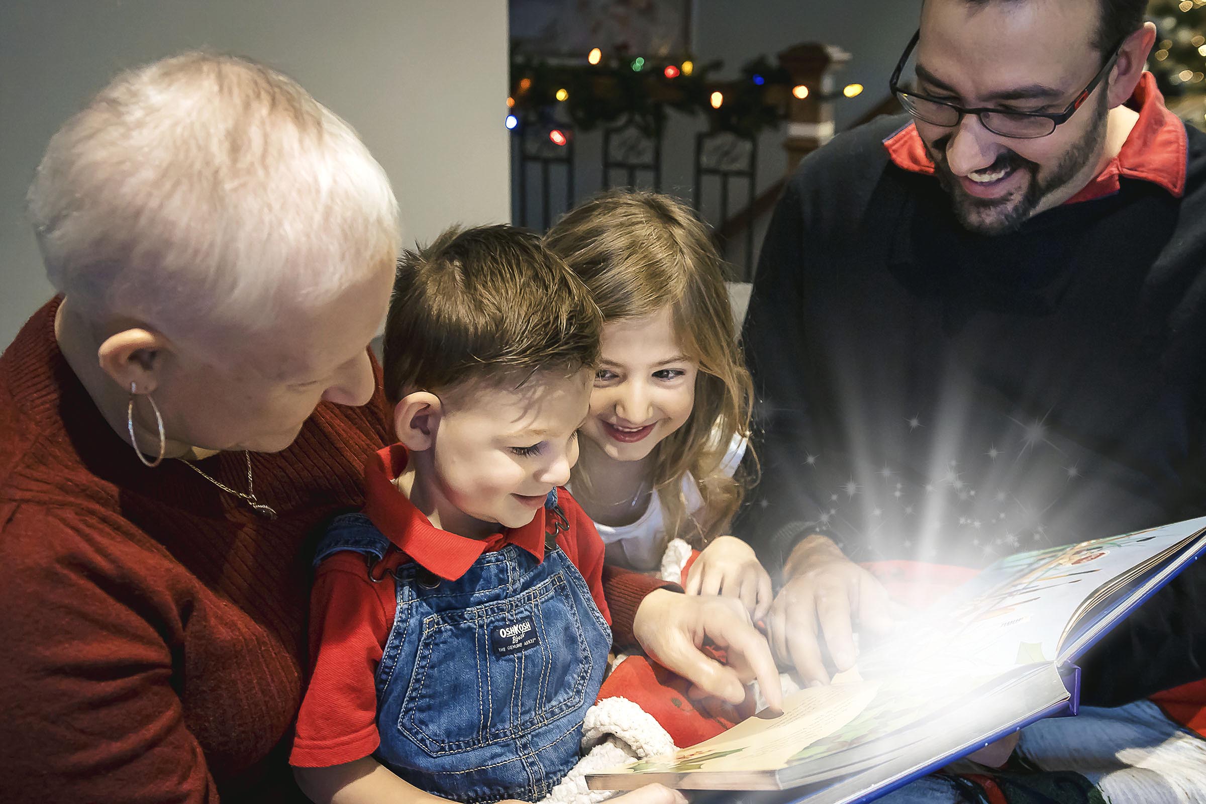 Portrait des fêtes famille enfants regarde un livre avec lueur magique par Tobi Malette photographe Vaudreuil-Soulanges et ouest de l'ile de montreal